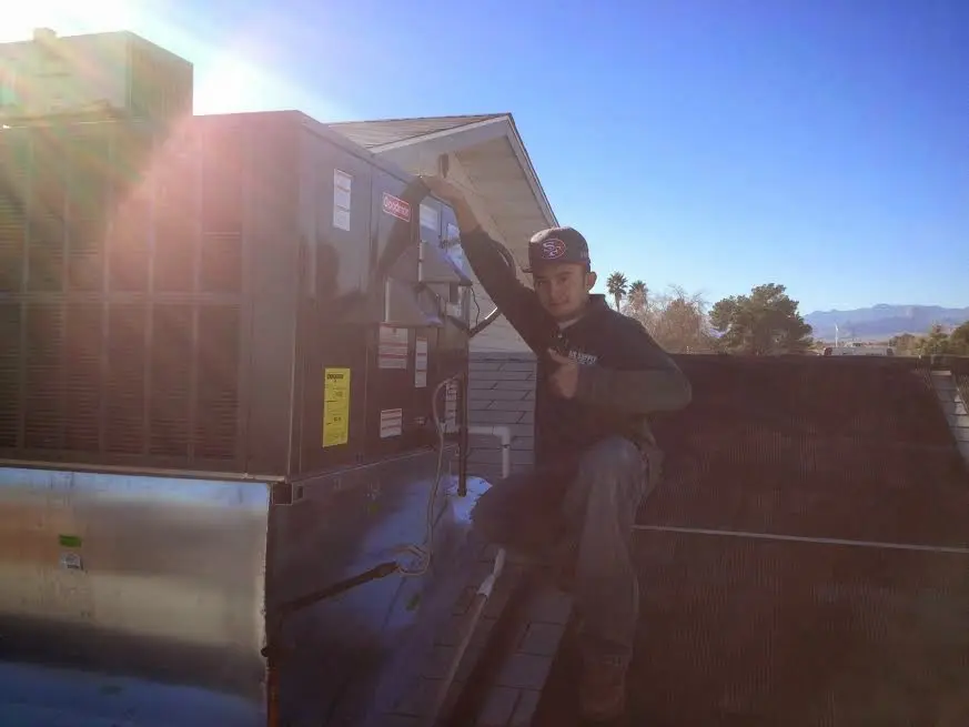 HVAC technician performing Air Duct Cleaning on a rooftop unit in Monticello